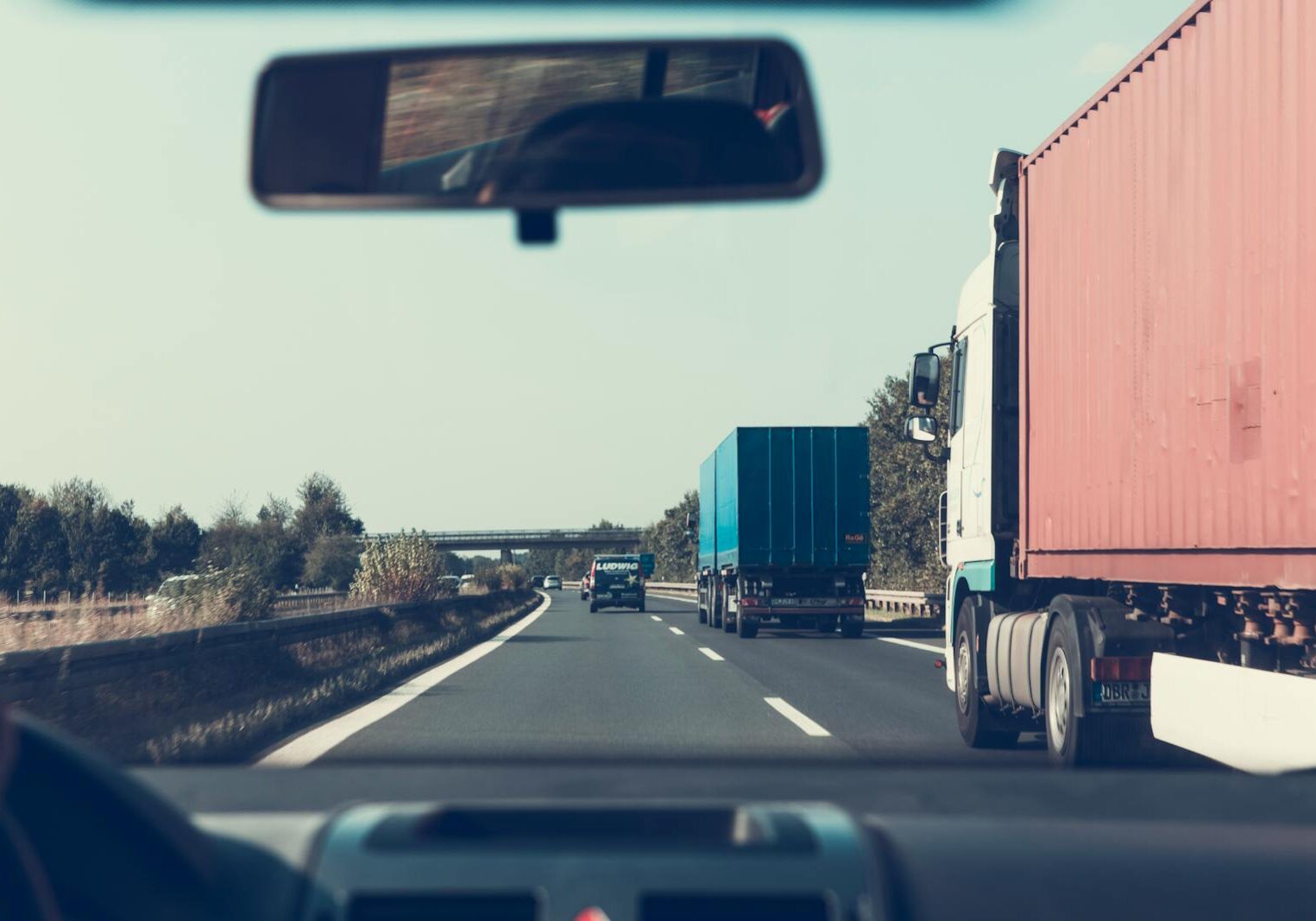 View through rearview mirror of a trucks on a highway, providing logistics transportation